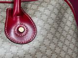 an image of a handbag with a red handle