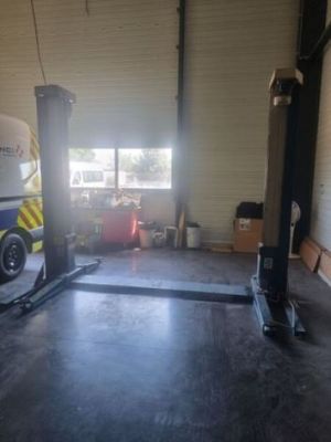 an image of a garage with a car on a lift