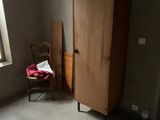 une armoire placée dans un coin de la pièce, avec une chaise à côté