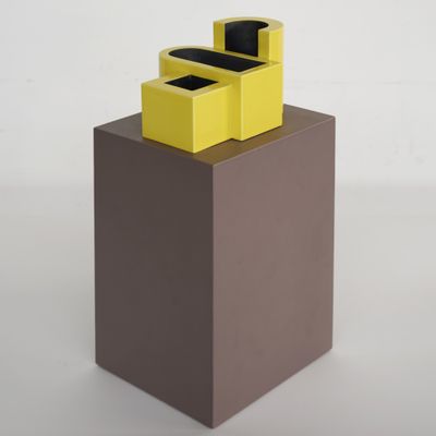 une boîte jaune surmontée de deux boîtes noires