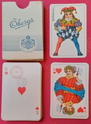 trois cartes à jouer sont posées les unes à côté des autres sur une surface rose