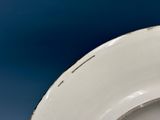 a close up of a white plate on a blue background