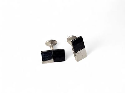 two black and silver cufflinks with a square design on them