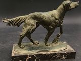 bronze statue of a dog on a marble base on a black background