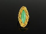 a gold ring with a green jade stone in the center