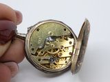 a person holding a pocket watch in their hand