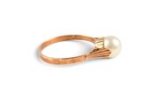 a close up of a gold ring with a pearl on it