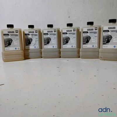 quatre bouteilles de liquide sont alignées sur une surface blanche