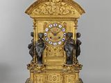 a gold clock that is sitting on a table