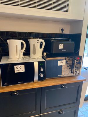two microwaves sitting on top of a kitchen counter