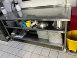 une cuisine avec un plan de travail en inox et un seau jaune
