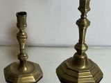 pair of antique brass candlesticks on a glass table