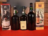 several bottles of wine are lined up on a red table