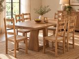 une table et des chaises en bois dans une pièce dotée d'une grande fenêtre