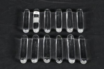 six clear plastic pill caps sitting on top of a black surface