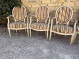three chairs sitting next to each other in front of a brick wall