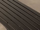 a black bench that is sitting on the ground