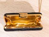 a black and gold purse on a wooden table