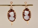 an image of a pair of earrings with a woman ' s profile on them