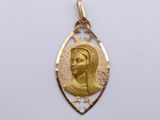 a close up of a gold pendant with a woman ' s face on it