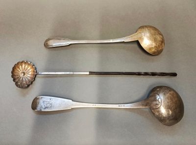 trois cuillères et un repose-cuillère posés côte à côte sur une table