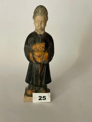 figurine représentant un moine tenant un bébé dans ses bras