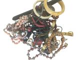 une pile de bijoux assortis sur une surface blanche