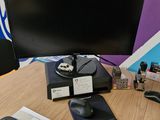 a desk with a computer monitor, keyboard, mouse, and other items on it