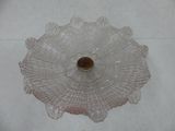 a pink glass bowl with a brown lid sitting on a table