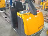a forklift in a warehouse with pallets in the background