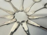 six spoons arranged in a circle on a table
