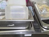 two trays of food sitting on top of a metal counter