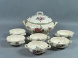 six tasses et une soucoupe avec un couvercle posées sur une table