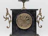 a black and gold clock sitting on a stand