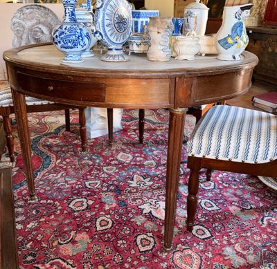 une table sur laquelle sont disposés de nombreux vases bleus et blancs