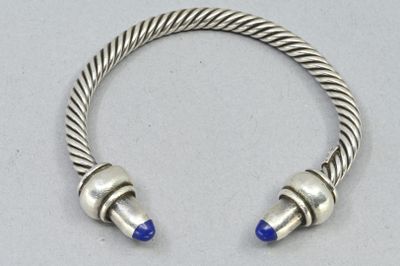 un gros plan sur un bracelet en argent orné de perles bleues