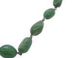 a close up of a necklace with green beads on a white background