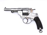 un gros plan d'un pistolet sur une surface blanche avec un fond blanc