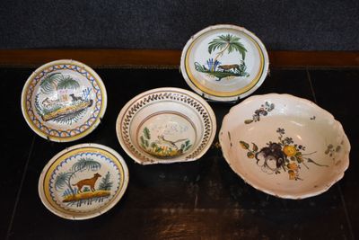 several plates and bowls are sitting on a wooden table