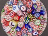 une photo d'un presse-papier en verre orné de fleurs