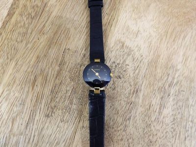 a watch that is laying on a wooden table