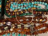 many different colored beads and necklaces on a table