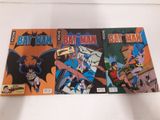 trois bandes dessinées Batman posées sur une surface blanche