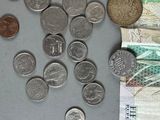 a pile of coins sitting on top of a table next to a pile of money