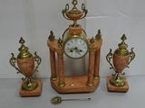a clock that is sitting on a table next to three vases
