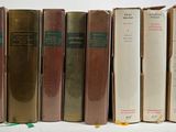 plusieurs vieux livres sont alignés sur une surface blanche