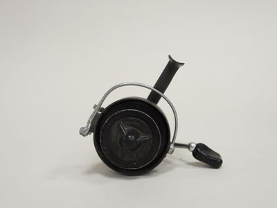 a small black clock with a black handle on a white surface
