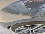 a reflection of a man taking a picture of a car