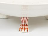 a white bowl with a red and white design on it