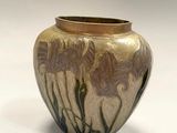 a vase that has flowers on it on a white surface
